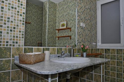 a bathroom with a sink and a basket on a counter at Apartamento Royal Centro de Ronda in Ronda