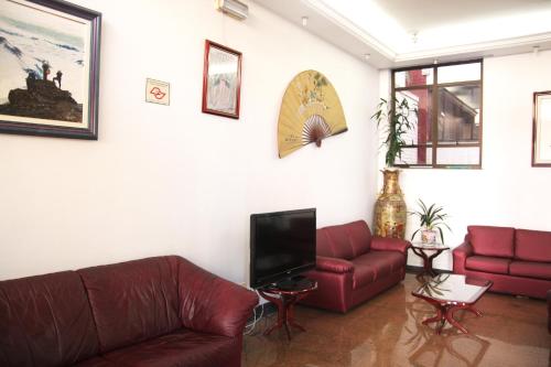 uma sala de estar com dois sofás e uma televisão em Free Palace Hotel em São Paulo