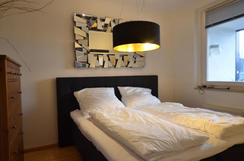 a bed in a bedroom with a light above it at ALL-IN-ONE Kurfuerstendamm in Berlin