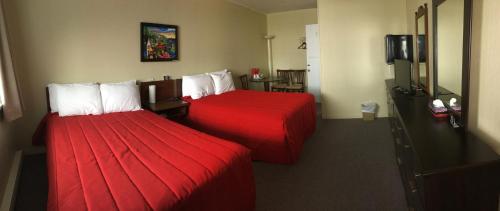 Un pat sau paturi într-o cameră la Motel Sainte-Flavie