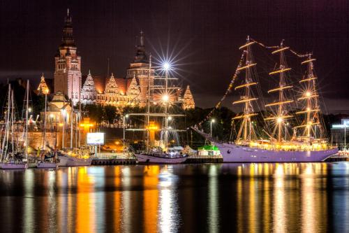 a group of boats docked in a harbor at night at Apartament MonteCassino in Szczecin