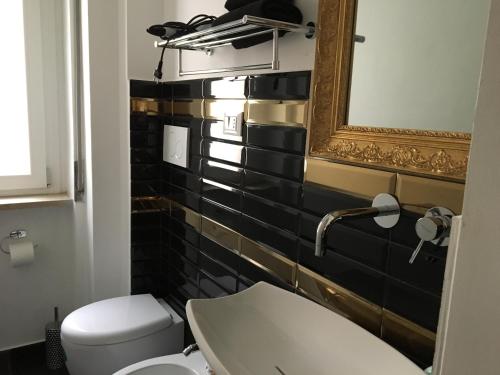 a bathroom with a toilet and a mirror and a sink at Casa Meri in Montesilvano