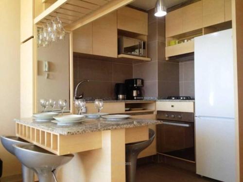 a kitchen with a counter with wine glasses on it at Departamento Costa de Montemar in Concón