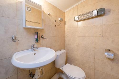 a bathroom with a sink and a toilet at Къща за гости "При Примо" in Zlatograd