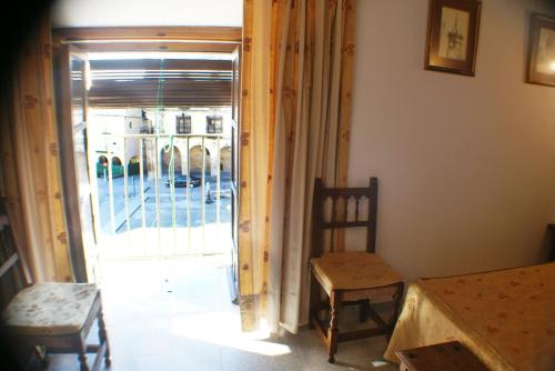 a room with an open door with a table and chairs at Hostal Meson la Cadena in Trujillo