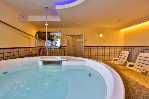 a jacuzzi tub in a room with two chairs at Metropolitan Hotel Brasília in Brasilia