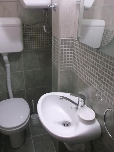 a bathroom with a white sink and a toilet at Vicky Apartments in Kotor