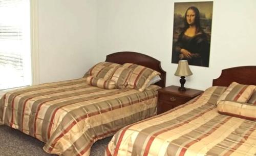 沃薩加比奇的住宿－Inn On The Beach，一间卧室设有两张床,墙上挂着一幅画