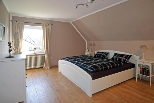 a bedroom with a large bed and a window at Ferienwohnung Maarland in Schalkenmehren