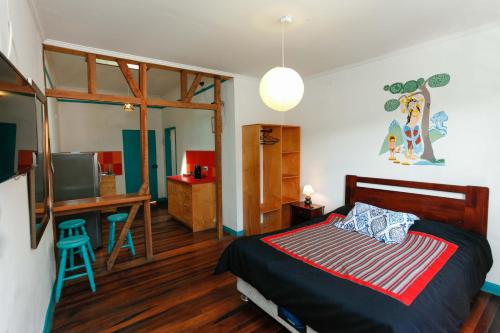 Dormitorio con cama, escritorio y TV en Casa Violeta Limón, en Valparaíso
