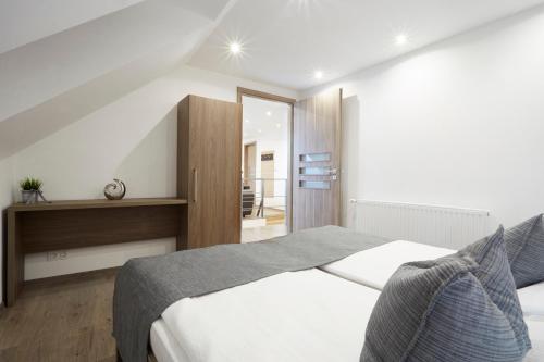 a bedroom with a large white bed in a room at Főtér Apartman in Villány