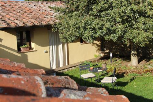 a house with a table and chairs in the yard at Da Leo in Montefollonico