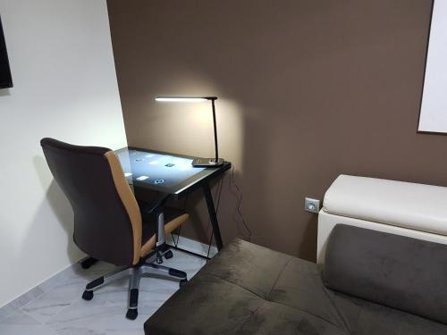 a desk with a lamp and a chair in a room at Route 77 in Thessaloniki