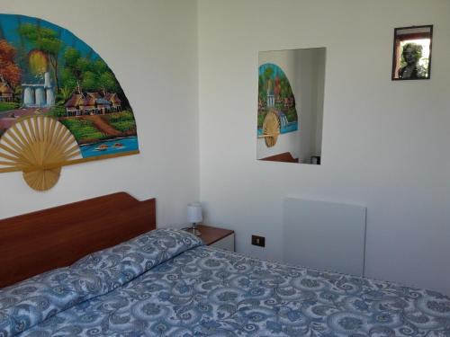 サバウディアにあるAfrodite Apartmentのベッドルーム1室(ベッド1台付)が備わります。壁には絵画が飾られています。