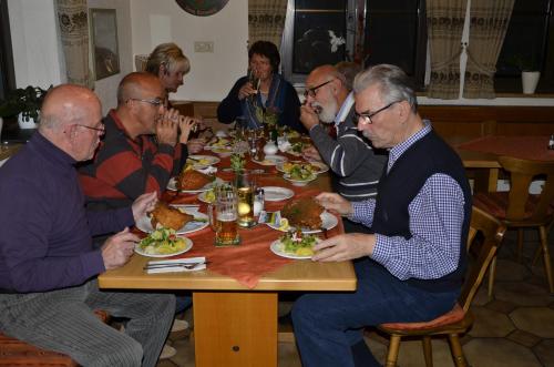 a group of people sitting around a table eating food at Pension Zum Grünen Wald in Feuchtwangen