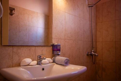 a bathroom with a sink and a mirror at Ulrika in Aegina Town