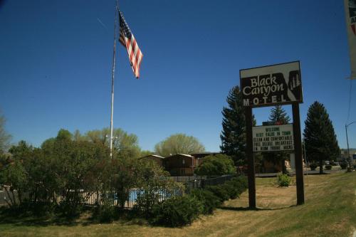 a sign and an american flag next to a sign at Black Canyon Motel in Montrose