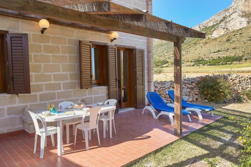 a patio with a table and chairs and a house at Case Canino in Favignana