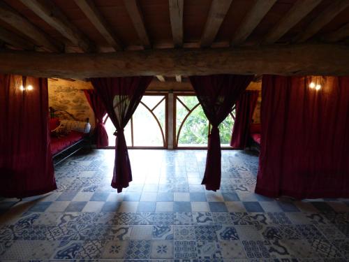 Caixas的住宿－Mas de la Fariole，一间设有红色窗帘和瓷砖地板的客房