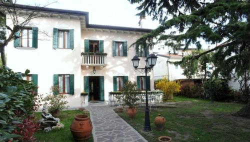 una casa blanca con una luz de la calle delante de ella en Villa Crispi, en Mestre