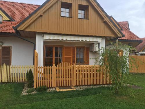 a house with a wooden fence in front of it at Apartma Jelenček in Moravske Toplice