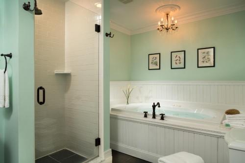 uma casa de banho com uma banheira e um lustre em Four Chimneys Inn em Bennington