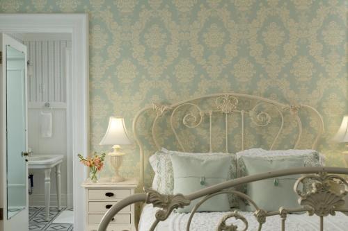 a bedroom with a bed with blue and gold wallpaper at Four Chimneys Inn in Bennington