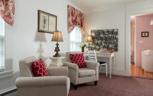a living room with two chairs and a desk at Four Chimneys Inn in Bennington