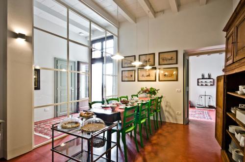 een eetkamer met een tafel en groene stoelen bij Relais Villa Ambrosetti in Verona