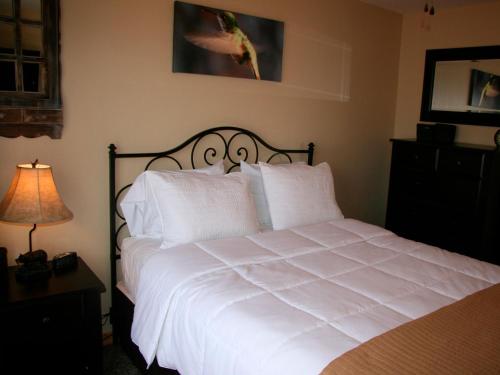 a bedroom with a bed with white sheets and a lamp at Montana Style Downtown Condo in Whitefish