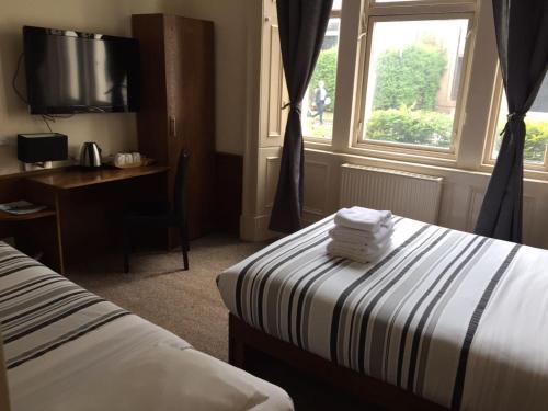 a hotel room with a bed and a desk and a window at Glasgow House in Glasgow