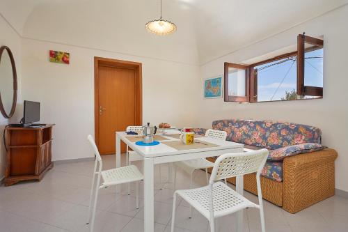 a living room with a table and chairs and a couch at Case Canino in Favignana