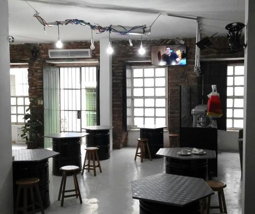 uma sala com mesas, bancos de bar e janelas em Pousada Terra Nossa em Salvador