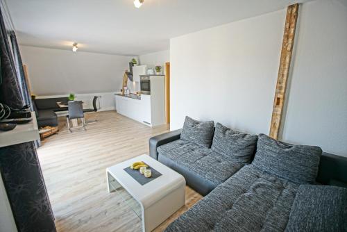 uma sala de estar com um sofá e uma mesa em Ostseeferienhaus oberes Apartment em Mönkebude