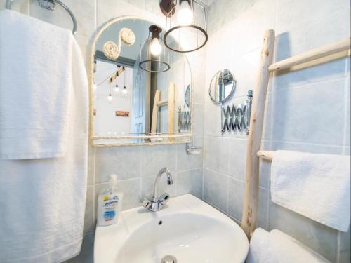 a bathroom with a sink and a mirror and towels at Evi Rooms in Aliki