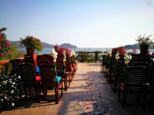 a row of chairs with flowers and confetti at Hotel Aura del Mar in Zihuatanejo
