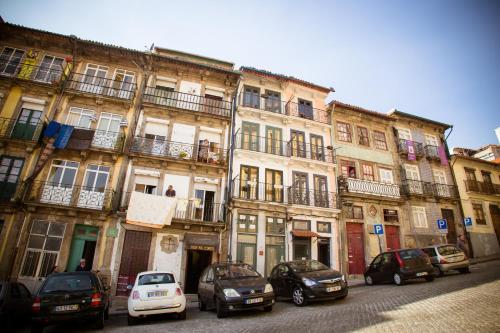 una fila di edifici con macchine parcheggiate di fronte a loro di Historical Porto Studios a Porto
