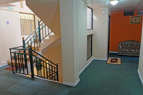 a hallway with stairs and a couch in a building at Hotel Bonaventure in Quito