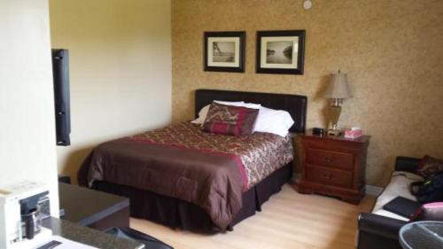 a bedroom with a bed and a dresser and a couch at MacNeil's Motel in North Sydney