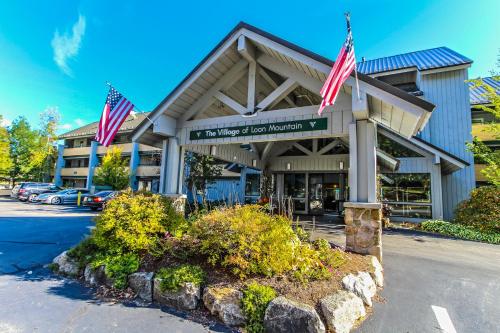 a building with two american flags in front of it at Village of Loon Mountain in Lincoln