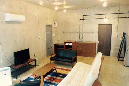 a living room with a couch and a tv at Retya in Ishigaki Island
