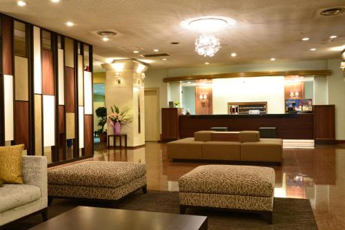 a lobby with a couch and chairs in a building at Hotel Sunroute Sano in Sano