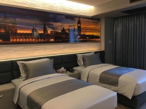 two beds in a hotel room with a painting on the wall at Maleewana Hotel & Resort in Ban Bang Muang