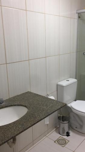 a bathroom with a sink and a toilet at Apartamento confortável in Goiânia