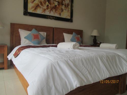 a bedroom with a large bed with white sheets at Amed Sunset Beach in Amed