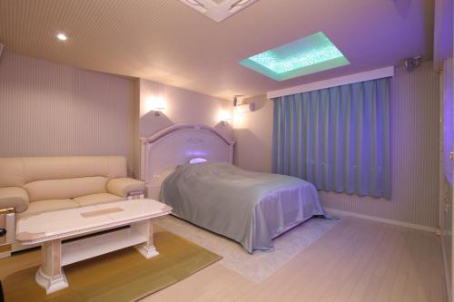 a hospital room with a bed and a couch at Hotel AtoZ Saku (Adult Only) in Saku