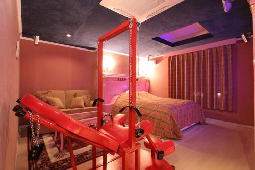 a bedroom with a bed and a red swing at Hotel AtoZ Saku (Adult Only) in Saku