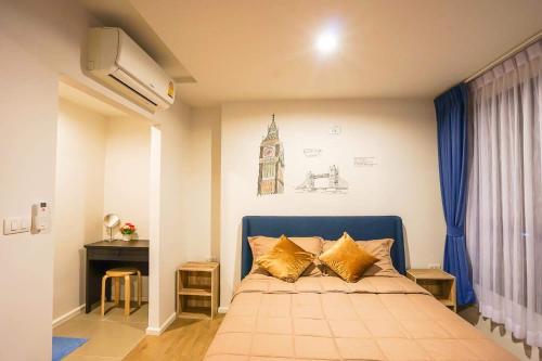 een slaapkamer met een blauw bed met gouden kussens bij Centrio by Suttirak in Phuket