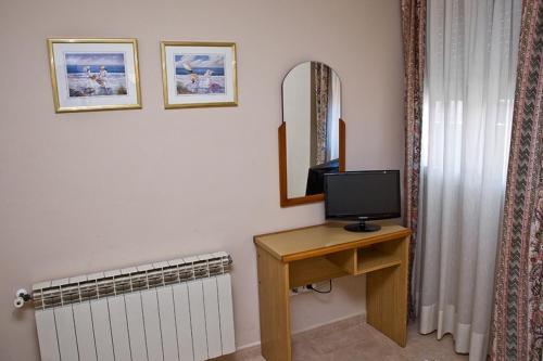a room with a desk with a television and a mirror at Hotel La Piqueta in Benasal