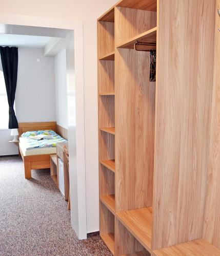 a room with a book shelf and a bedroom at Motel Vega in Sezimovo Ústí